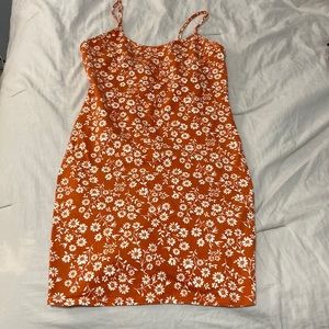 Orange dress with flowers and back cut out. Size s. Brand is forever 21
